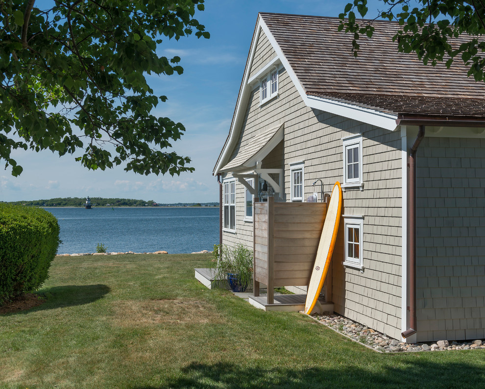 This is an example of a beach style two-storey grey exterior in Providence with wood siding.
