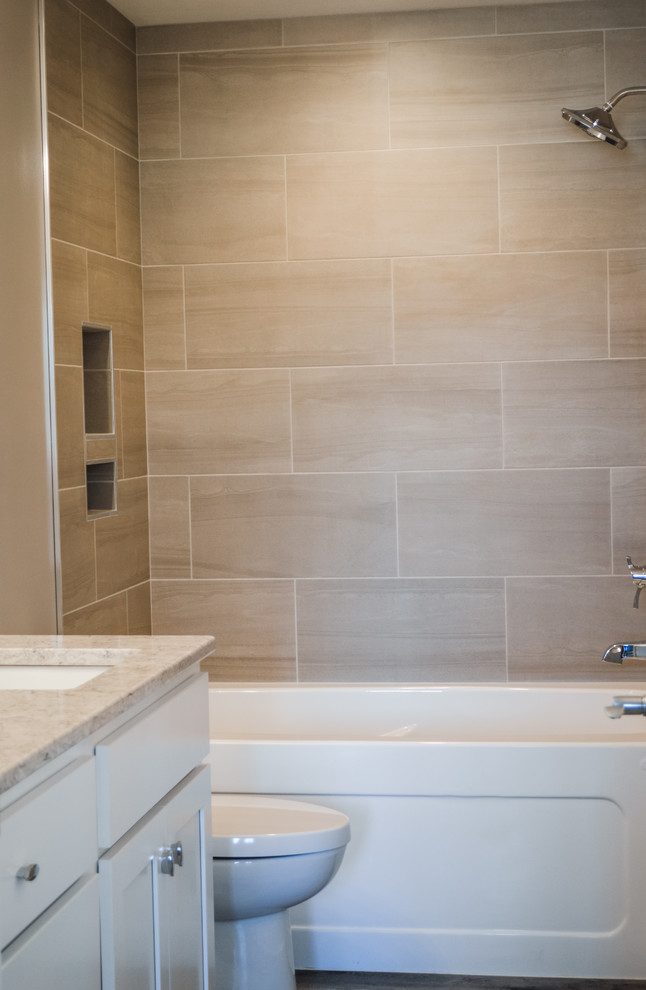 Photo of a mid-sized arts and crafts kids bathroom in Other with shaker cabinets, white cabinets, an alcove tub, a shower/bathtub combo, a one-piece toilet, beige tile, ceramic tile, beige walls, an undermount sink, engineered quartz benchtops, an open shower and white benchtops.