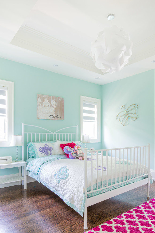 Transitional kids' bedroom in Toronto with blue walls and dark hardwood floors for girls.