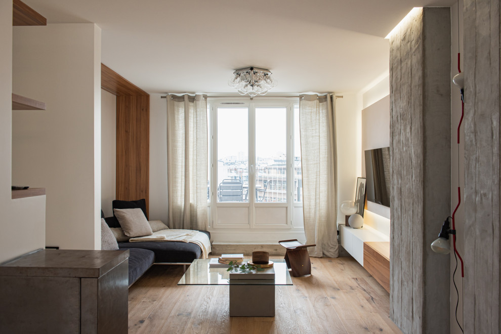 Mittelgroßes, Offenes Modernes Wohnzimmer ohne Kamin mit weißer Wandfarbe, hellem Holzboden, TV-Wand, beigem Boden, Holzwänden und vertäfelten Wänden in Paris