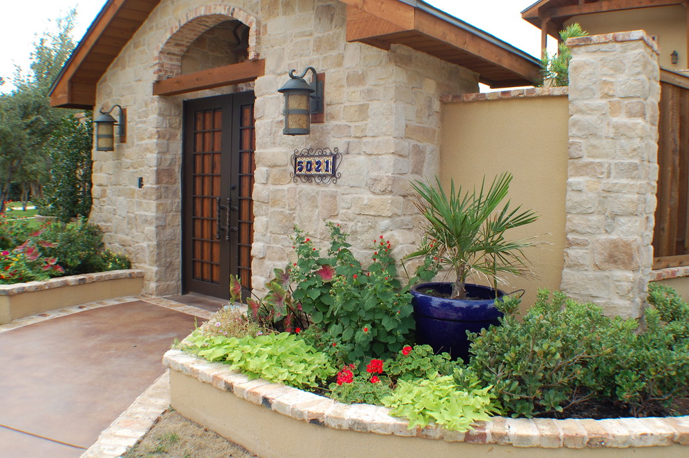 This is an example of a mediterranean two-storey stucco beige exterior in Austin with a hip roof.