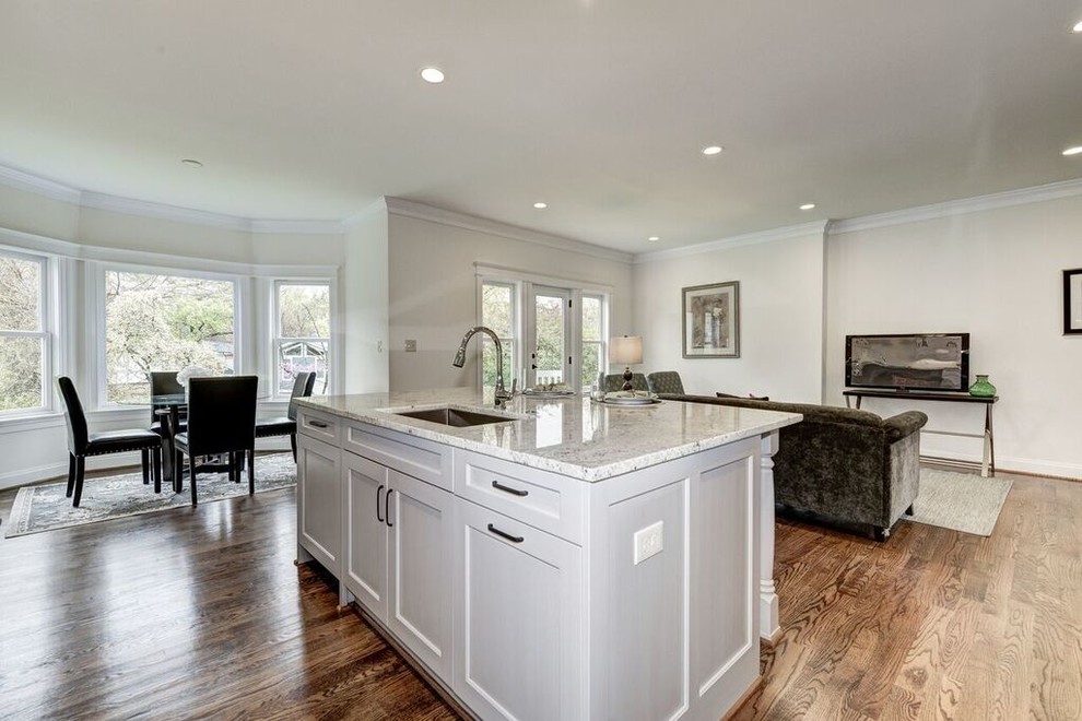 Inspiration for a large transitional l-shaped medium tone wood floor eat-in kitchen remodel in DC Metro with a drop-in sink, beaded inset cabinets, white cabinets, granite countertops, white backsplash, stainless steel appliances and an island