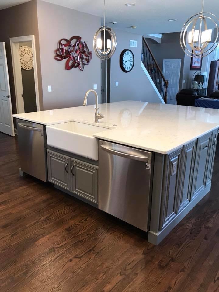 Open concept kitchen - mid-sized transitional u-shaped medium tone wood floor and brown floor open concept kitchen idea in Cincinnati with a farmhouse sink, glass-front cabinets, white cabinets, quartz countertops, gray backsplash, subway tile backsplash, stainless steel appliances, an island and white countertops