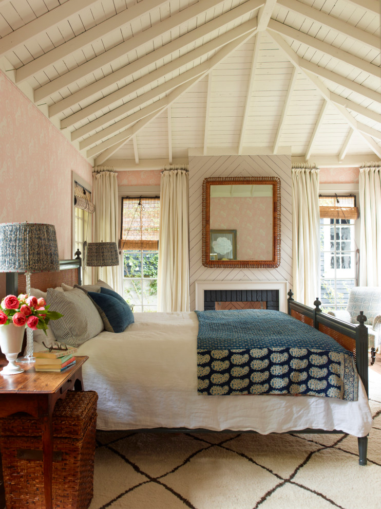 Imagen de dormitorio principal y blanco de estilo de casa de campo con paredes rosas, todas las chimeneas, marco de chimenea de ladrillo y vigas vistas