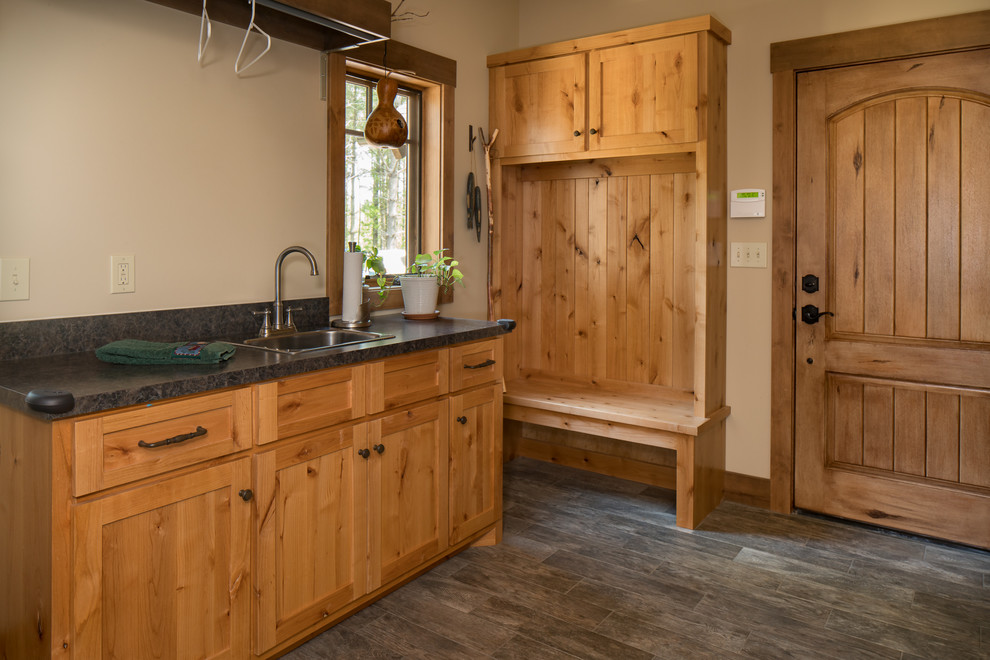 Design ideas for a mid-sized country single-wall utility room in Other with a drop-in sink, shaker cabinets, distressed cabinets, granite benchtops, beige walls, laminate floors and grey floor.