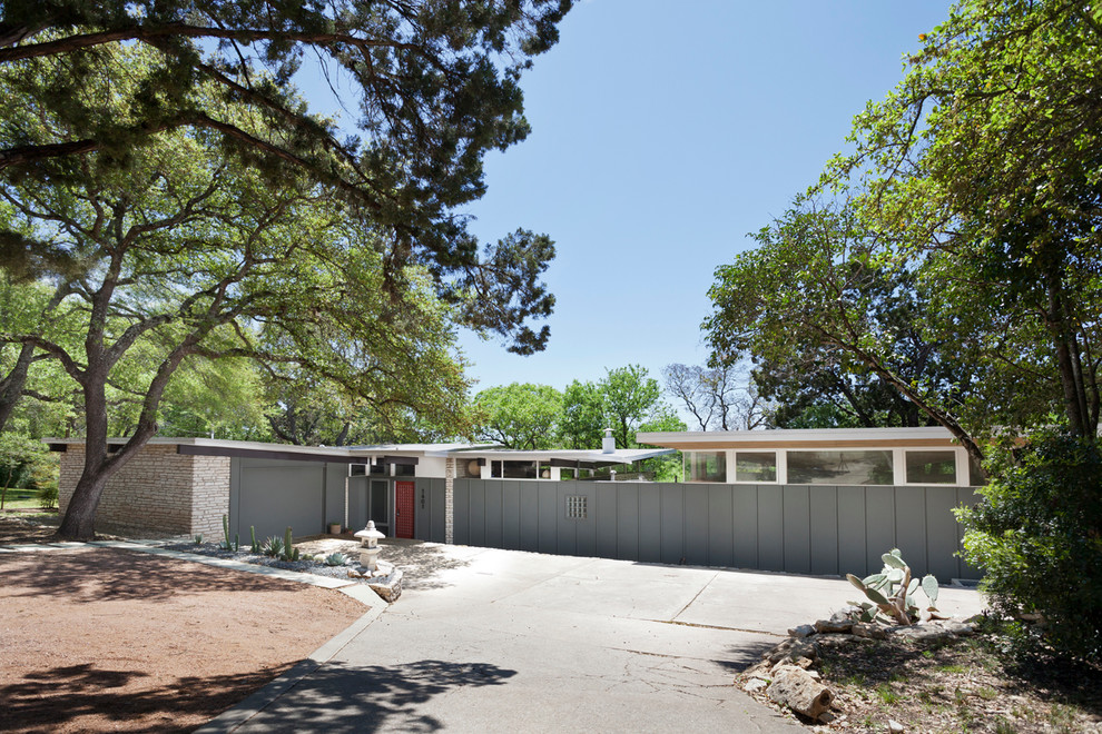 Midcentury one-storey grey exterior in Austin with a shed roof.