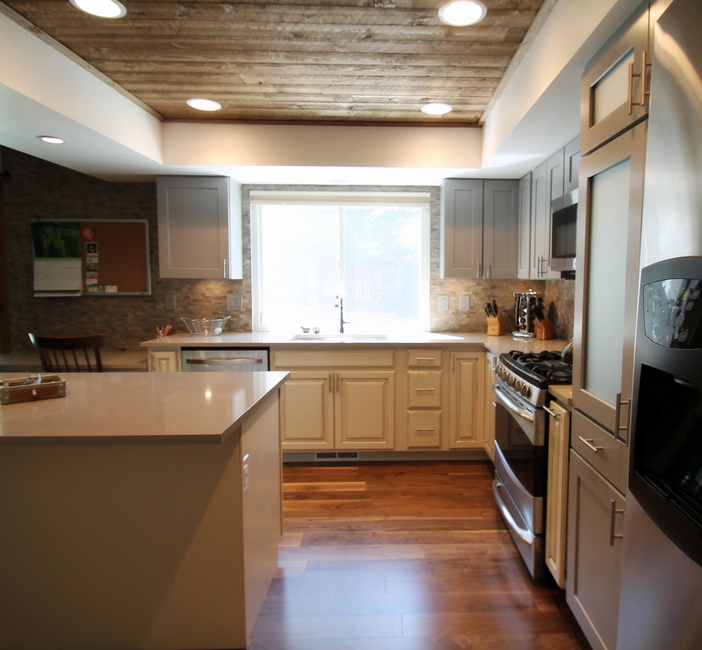 Inspiration for a large transitional l-shaped medium tone wood floor eat-in kitchen remodel in Denver with an undermount sink, shaker cabinets, gray cabinets, quartz countertops, gray backsplash, stone tile backsplash, stainless steel appliances and an island