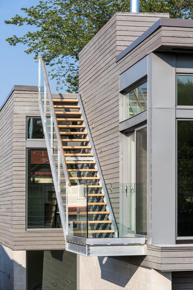 This is an example of a large modern two-storey grey exterior in Ottawa with mixed siding and a flat roof.