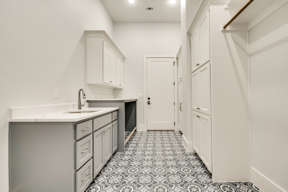 This is an example of a large mediterranean galley dedicated laundry room in Dallas with shaker cabinets.