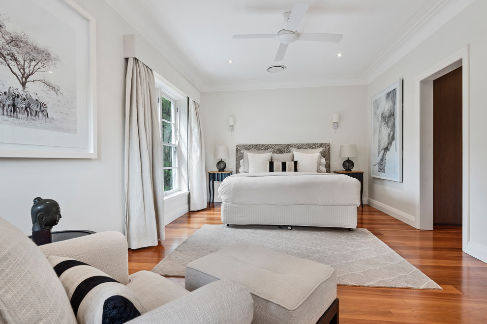 Design ideas for a mid-sized traditional bedroom in Sydney with white walls, medium hardwood floors and brown floor.