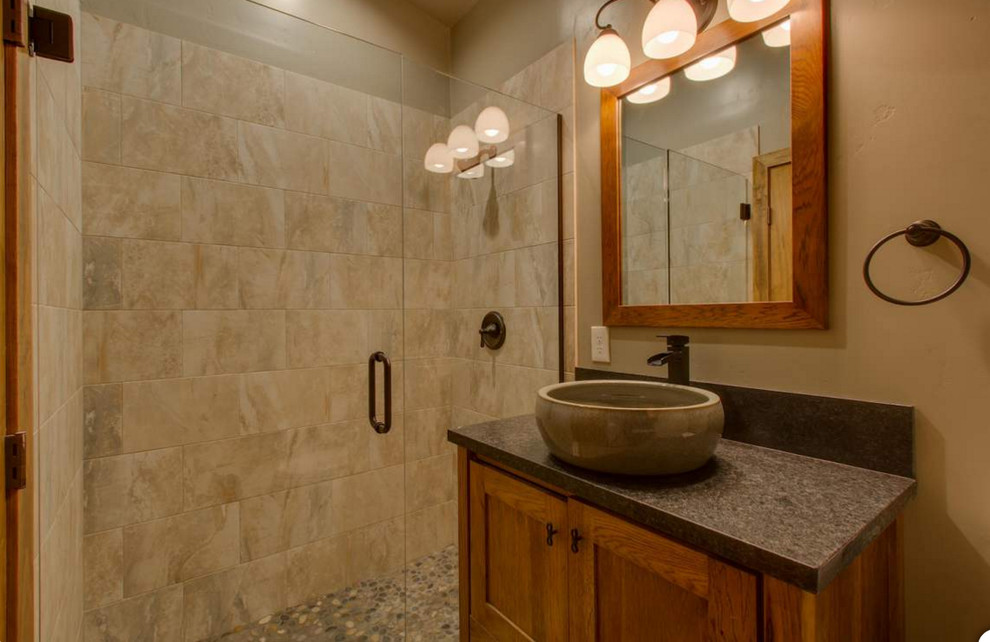This is an example of a mid-sized country kids bathroom in Sacramento with shaker cabinets, medium wood cabinets, an alcove tub, a shower/bathtub combo, a two-piece toilet, beige tile, porcelain tile, beige walls, porcelain floors, a vessel sink and granite benchtops.