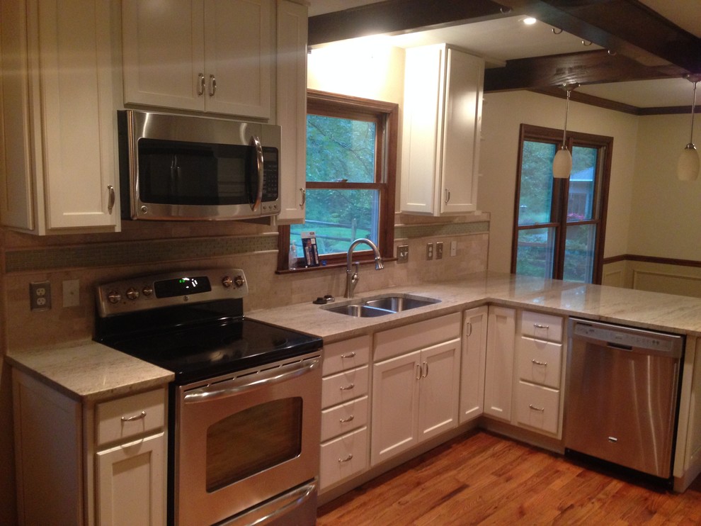 Kitchen - mid-sized transitional l-shaped medium tone wood floor kitchen idea in Cincinnati with a double-bowl sink, raised-panel cabinets, white cabinets, granite countertops, beige backsplash, ceramic backsplash and stainless steel appliances