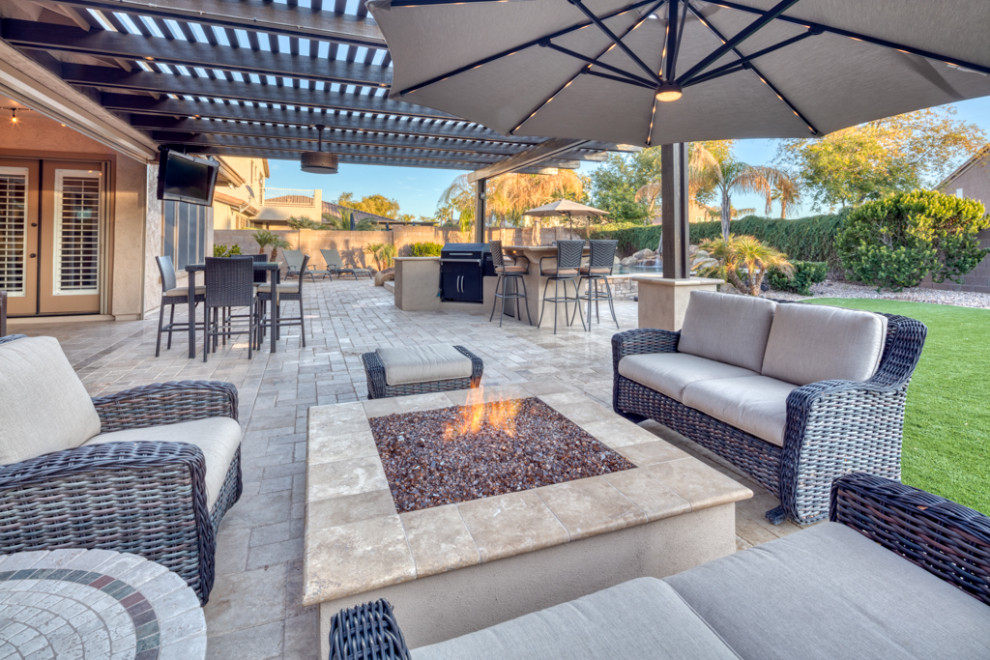Large contemporary backyard patio in Phoenix with an outdoor kitchen, concrete pavers and a pergola.