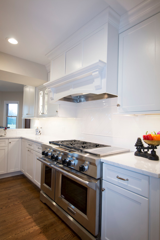 Example of a huge transitional medium tone wood floor open concept kitchen design with an undermount sink, shaker cabinets, white cabinets, marble countertops, white backsplash, ceramic backsplash, stainless steel appliances and two islands