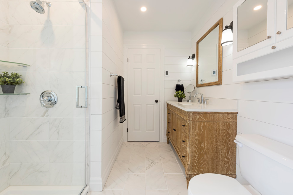 Photo of a mid-sized country master bathroom in Ottawa with distressed cabinets, a corner shower, a two-piece toilet, white tile, porcelain tile, white walls, porcelain floors, an undermount sink, engineered quartz benchtops, white floor, a hinged shower door and shaker cabinets.