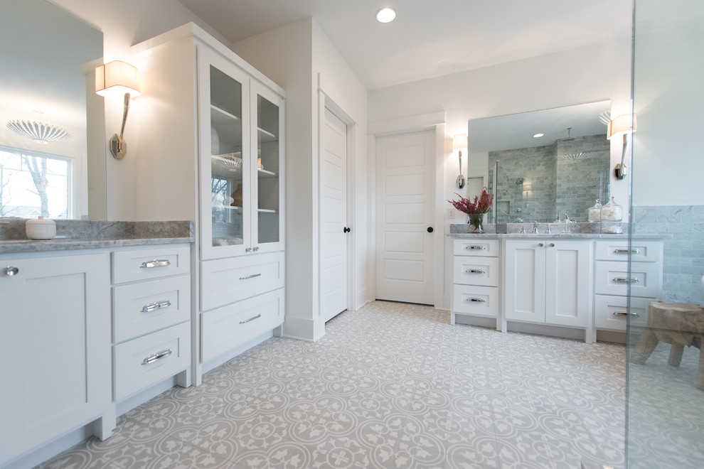 Inspiration for a large arts and crafts master bathroom in Indianapolis with shaker cabinets, white cabinets, a freestanding tub, a corner shower, a one-piece toilet, gray tile, cement tile, white walls, cement tiles, a drop-in sink and marble benchtops.