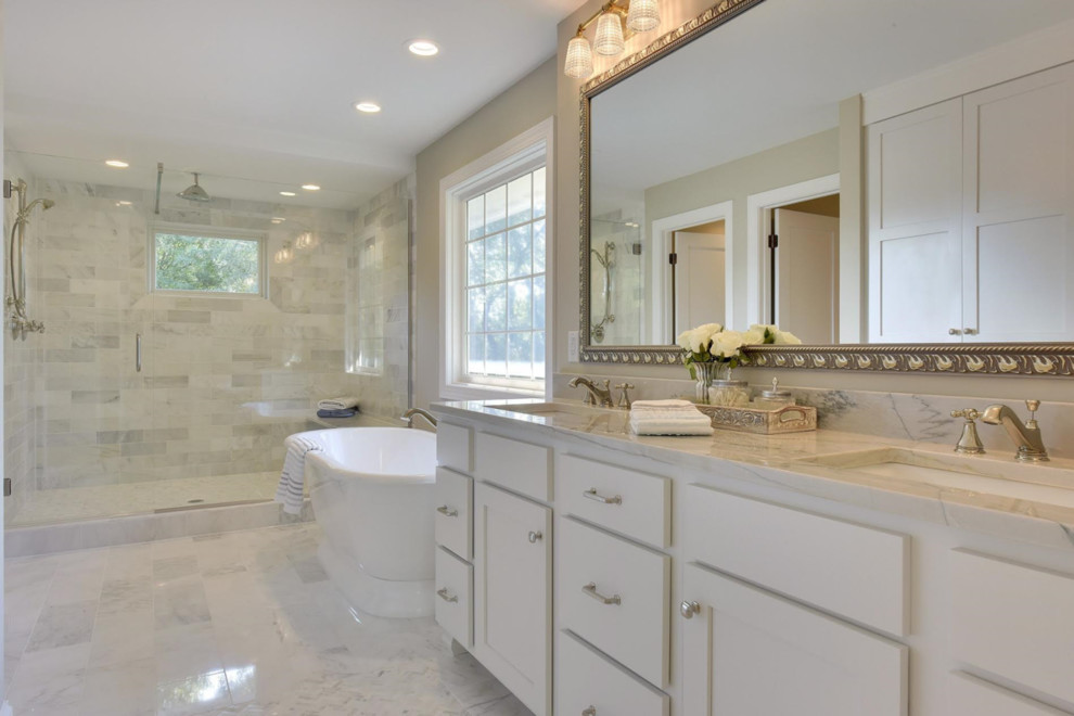 Inspiration for a large transitional master bathroom in Minneapolis with shaker cabinets, white cabinets, a freestanding tub, an alcove shower, gray tile, grey walls, marble floors, an undermount sink, marble benchtops, grey floor, a hinged shower door and grey benchtops.