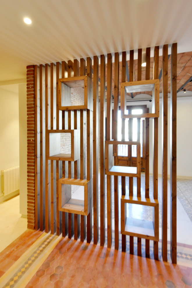 Пример оригинального дизайна: большая узкая прихожая в стиле модернизм с белыми стенами, полом из керамической плитки, одностворчатой входной дверью, металлической входной дверью, серым полом, сводчатым потолком и кирпичными стенами