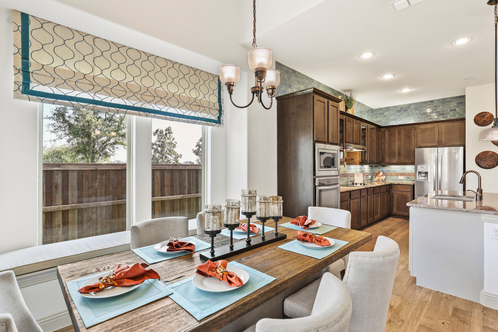 This is an example of a large contemporary l-shaped eat-in kitchen in Dallas with an undermount sink, raised-panel cabinets, dark wood cabinets, limestone benchtops, blue splashback, subway tile splashback, stainless steel appliances, medium hardwood floors, with island, brown floor and brown benchtop.