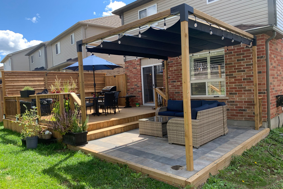 This is an example of a traditional back patio in Toronto with a pergola.