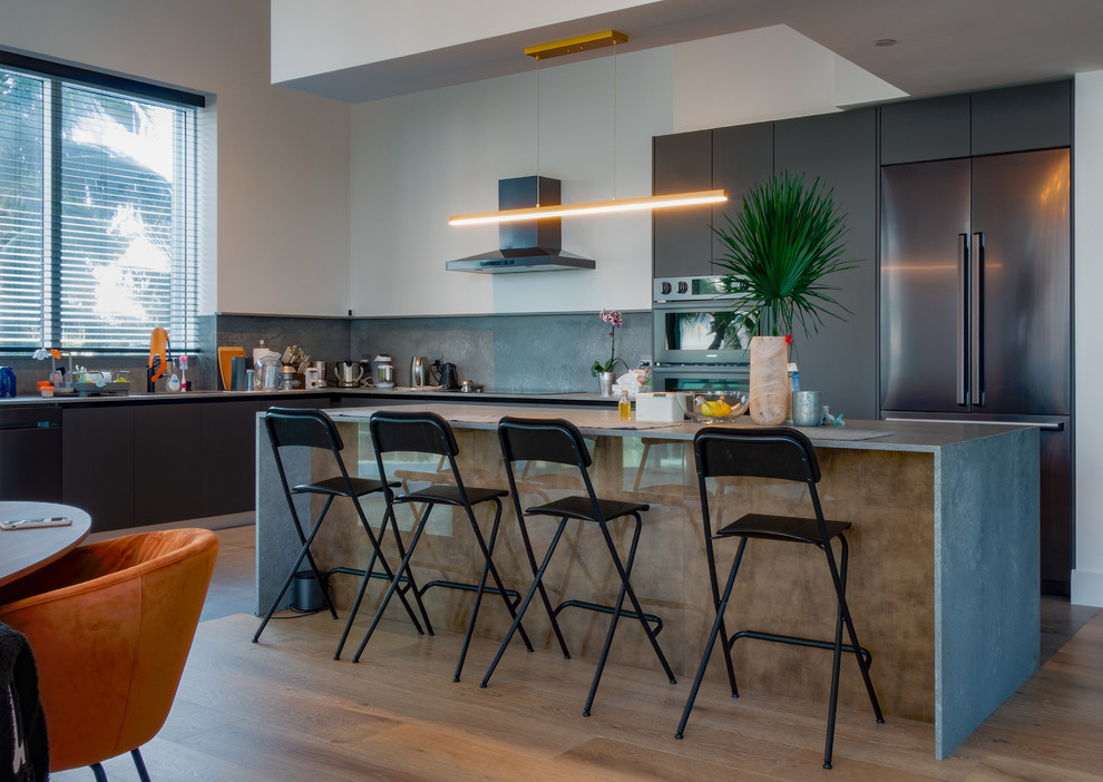This is an example of a mid-sized modern l-shaped separate kitchen in Miami with flat-panel cabinets, grey cabinets, concrete benchtops, grey splashback, cement tile splashback, stainless steel appliances, with island and grey benchtop.