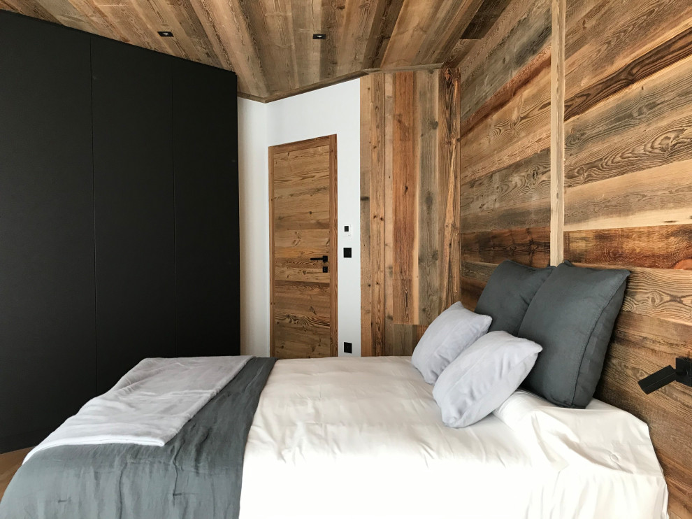 Diseño de dormitorio principal rural grande con paredes beige, suelo de madera en tonos medios, suelo beige, madera y madera