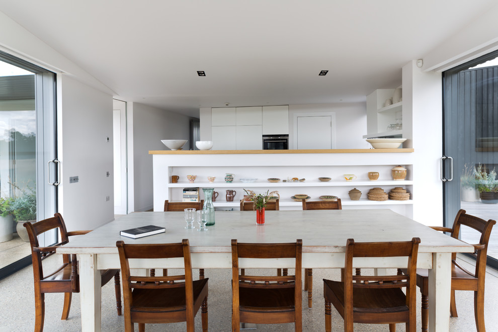 This is an example of a contemporary open plan dining in London with white walls.