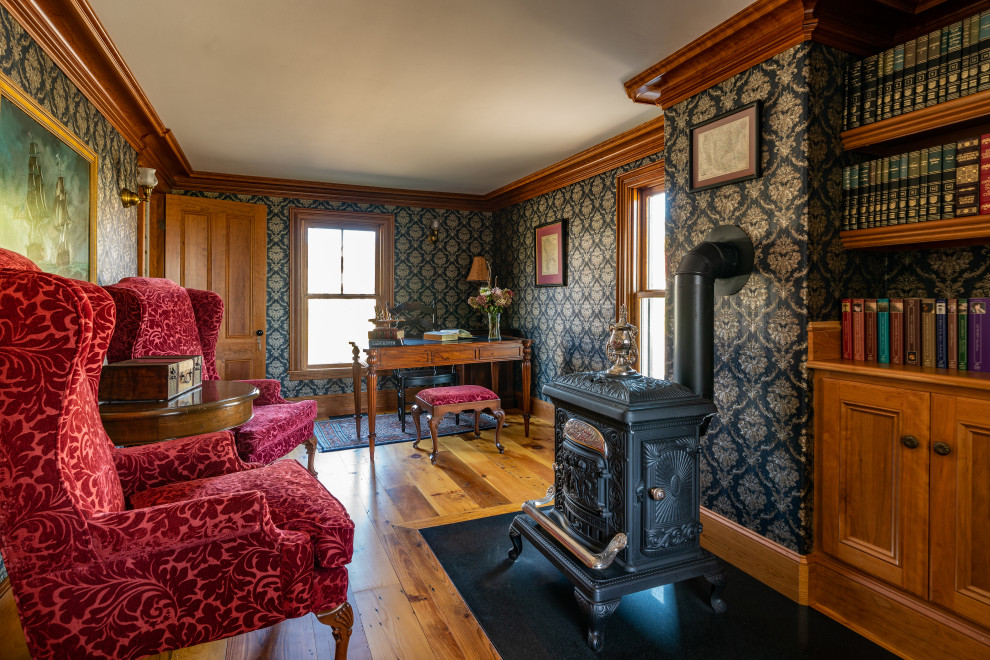ボストンにあるヴィクトリアン調のおしゃれなホームオフィス・書斎 (青い壁、無垢フローリング、薪ストーブ、壁紙) の写真