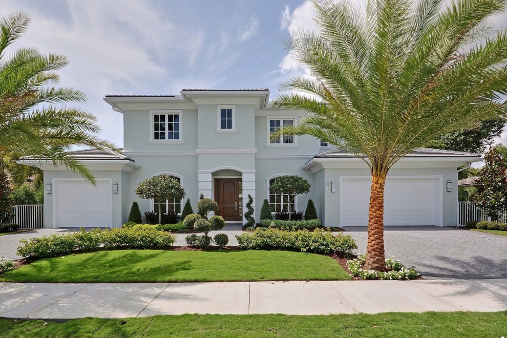 Inspiration for a large transitional two-storey stucco green exterior in Orange County with a hip roof.