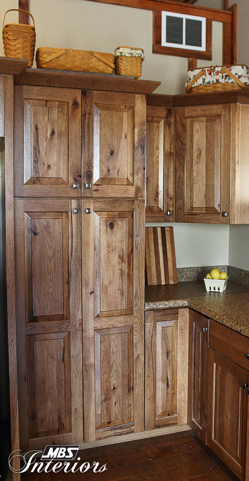 Inspiration for a rustic l-shaped kitchen remodel in Columbus with recessed-panel cabinets, medium tone wood cabinets, laminate countertops and black appliances