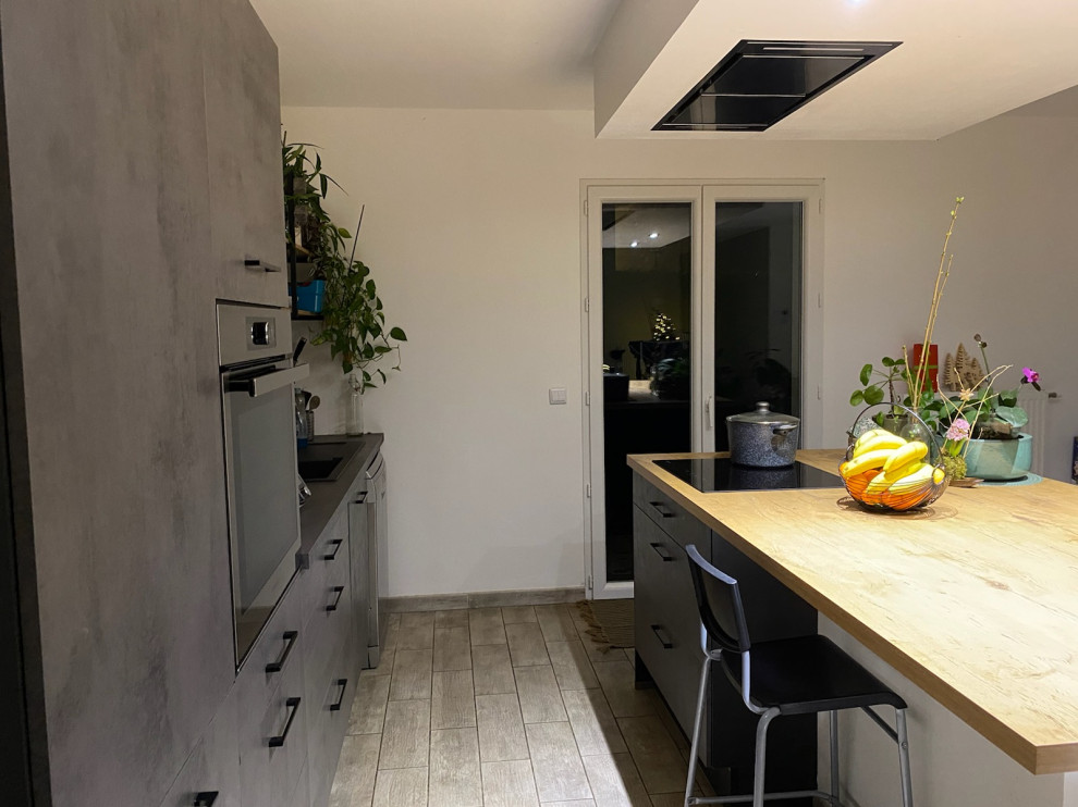 Immagine di un grande cucina con isola centrale moderno con ante grigie, top in legno, elettrodomestici in acciaio inossidabile, pavimento grigio e soffitto a cassettoni