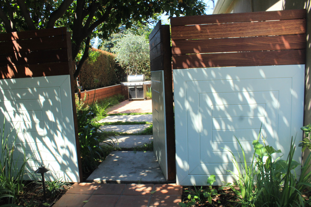 Idee per un giardino bohémian esposto a mezz'ombra di medie dimensioni e davanti casa in primavera con pavimentazioni in pietra naturale e recinzione in legno