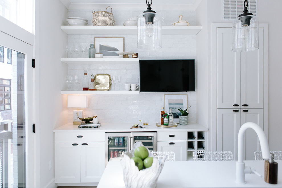Inspiration for a mid-sized transitional galley dark wood floor and gray floor enclosed kitchen remodel in DC Metro with an undermount sink, recessed-panel cabinets, white cabinets, solid surface countertops, stainless steel appliances, an island, white countertops, white backsplash and subway tile backsplash