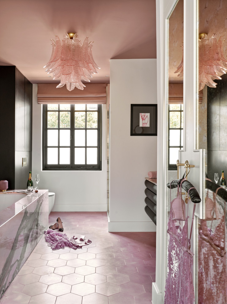Modelo de cuarto de baño flotante actual con puertas de armario negras, bañera encastrada sin remate, paredes blancas, suelo rosa y encimeras rosas
