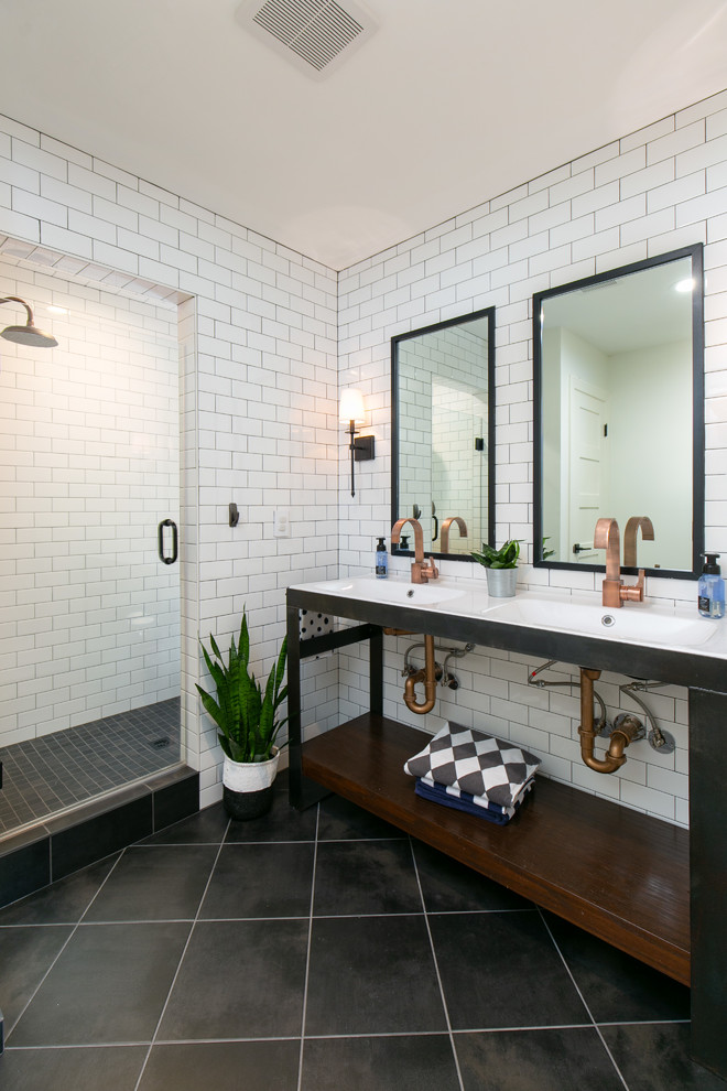 Small transitional 3/4 bathroom in Kansas City with open cabinets, an open shower, white tile, white walls, porcelain floors, an integrated sink, solid surface benchtops, black floor, a hinged shower door, white benchtops, black cabinets and subway tile.