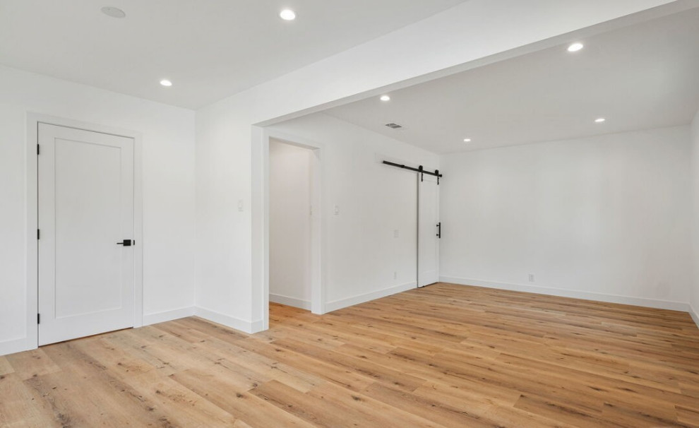Esempio di un'ampia camera da letto design con pareti bianche, pavimento in legno massello medio e pavimento marrone