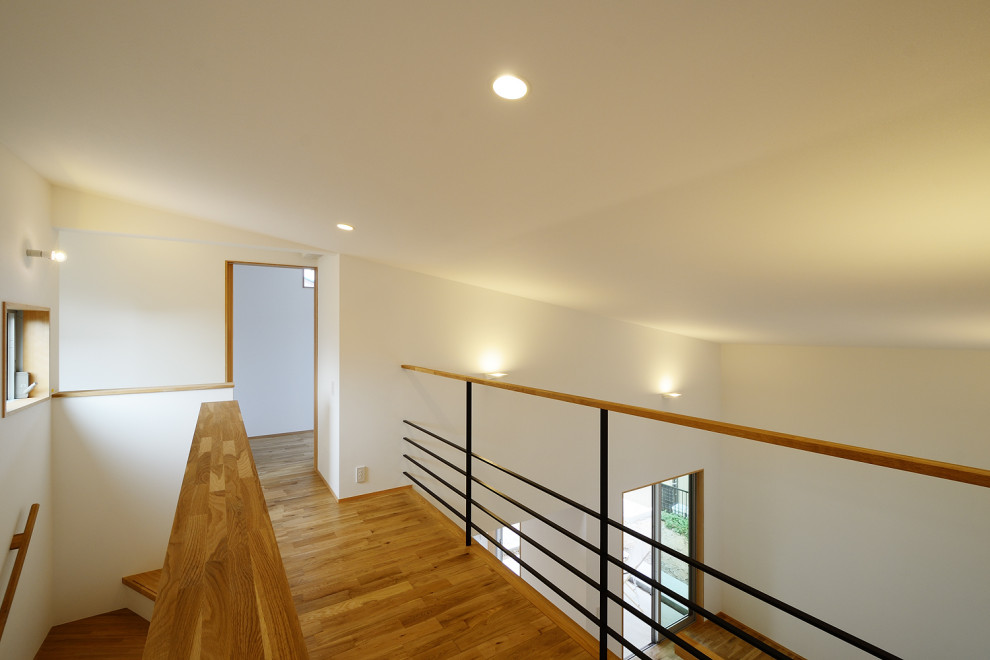 Cette image montre une salle de séjour minimaliste avec un mur blanc, un sol en vinyl, un sol beige, un plafond en papier peint et du papier peint.