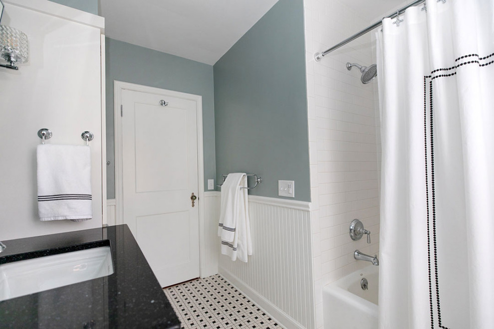 This is an example of a mid-sized transitional master bathroom in Other with vaulted, shaker cabinets, white cabinets, an alcove tub, an alcove shower, a two-piece toilet, white tile, subway tile, blue walls, mosaic tile floors, an undermount sink, engineered quartz benchtops, multi-coloured floor, a shower curtain, black benchtops, a single vanity, a built-in vanity and decorative wall panelling.
