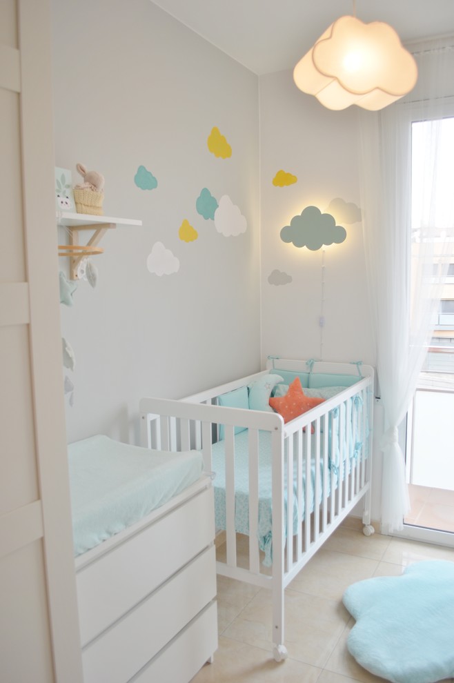 Photo of a small contemporary gender-neutral nursery in Other with grey walls, porcelain floors and beige floor.