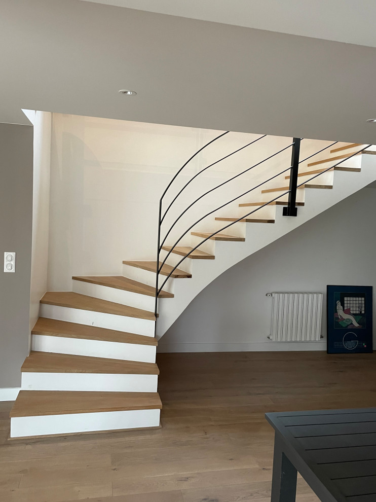 Inspiration pour un escalier design en L de taille moyenne avec des marches en bois, des contremarches en béton, un garde-corps en métal, du papier peint et palier.