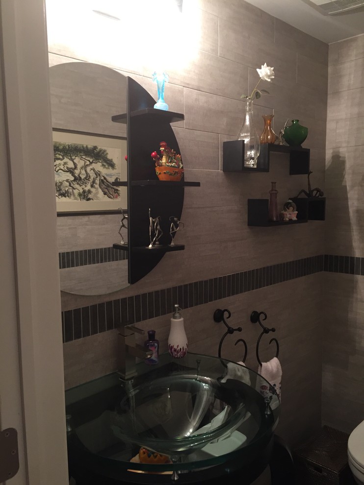 This is an example of a small asian bathroom in New York with open cabinets, a one-piece toilet, brown tile, ceramic tile, grey walls, porcelain floors, a pedestal sink and glass benchtops.