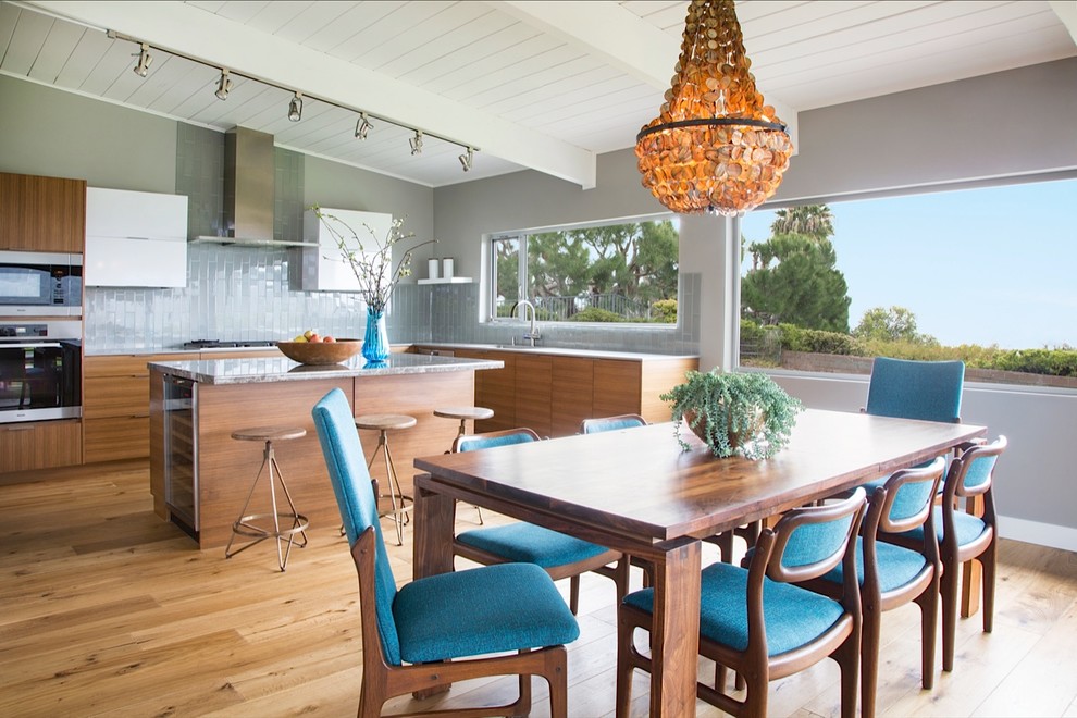 This is an example of a midcentury kitchen in Other with flat-panel cabinets, medium wood cabinets, marble benchtops, grey splashback, glass tile splashback, medium hardwood floors and with island.