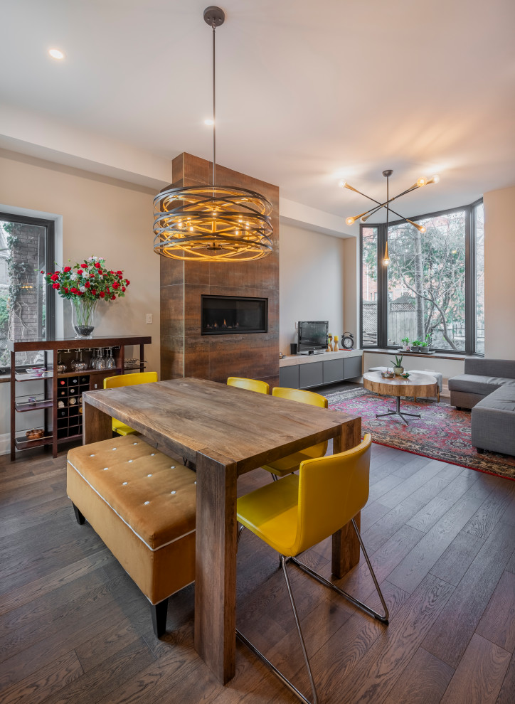 This is an example of a mid-sized contemporary open plan dining in Toronto with white walls, medium hardwood floors, a ribbon fireplace and brown floor.