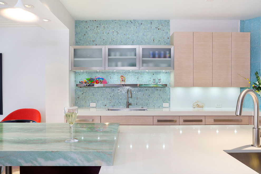 This is an example of a large eat-in kitchen in Miami with an undermount sink, flat-panel cabinets, light wood cabinets, granite benchtops, green splashback, glass sheet splashback, panelled appliances, with island and green benchtop.