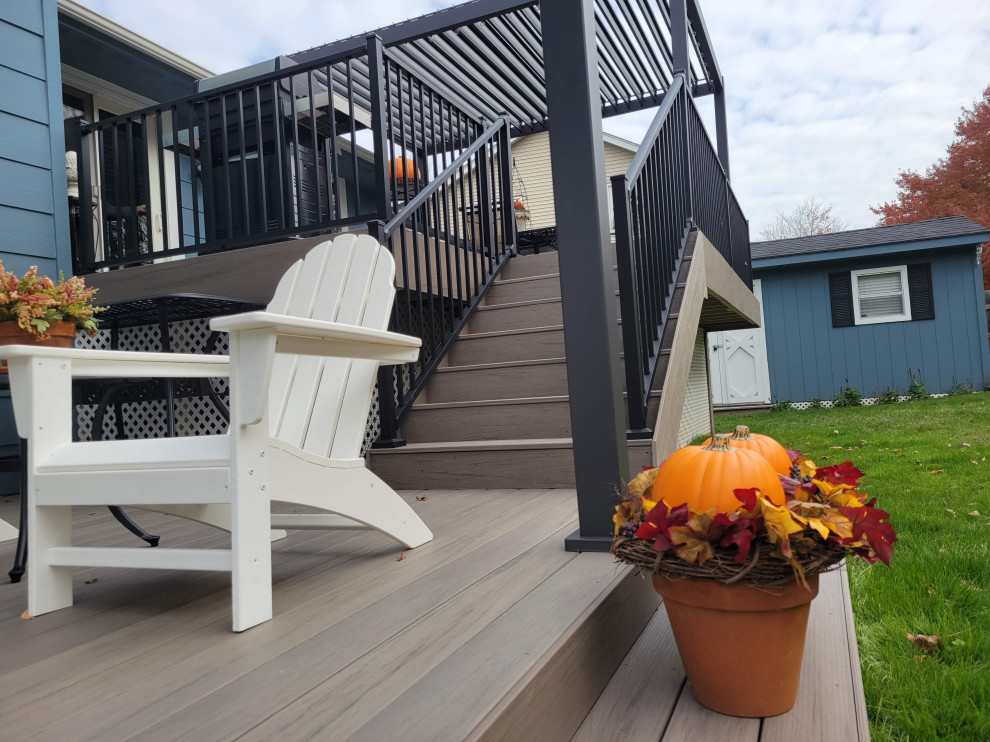 Deck - large backyard ground level metal railing deck idea with a pergola
