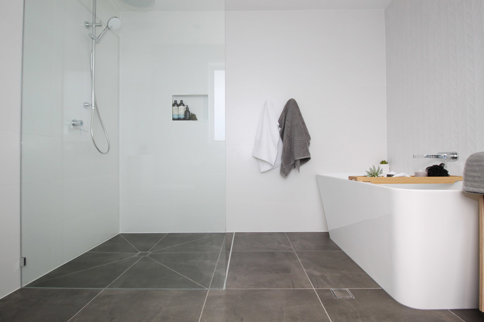 Inspiration for a mid-sized contemporary master bathroom in Brisbane with flat-panel cabinets, light wood cabinets, a freestanding tub, an open shower, a two-piece toilet, white tile, ceramic tile, white walls, porcelain floors, a vessel sink, engineered quartz benchtops, grey floor, an open shower and white benchtops.