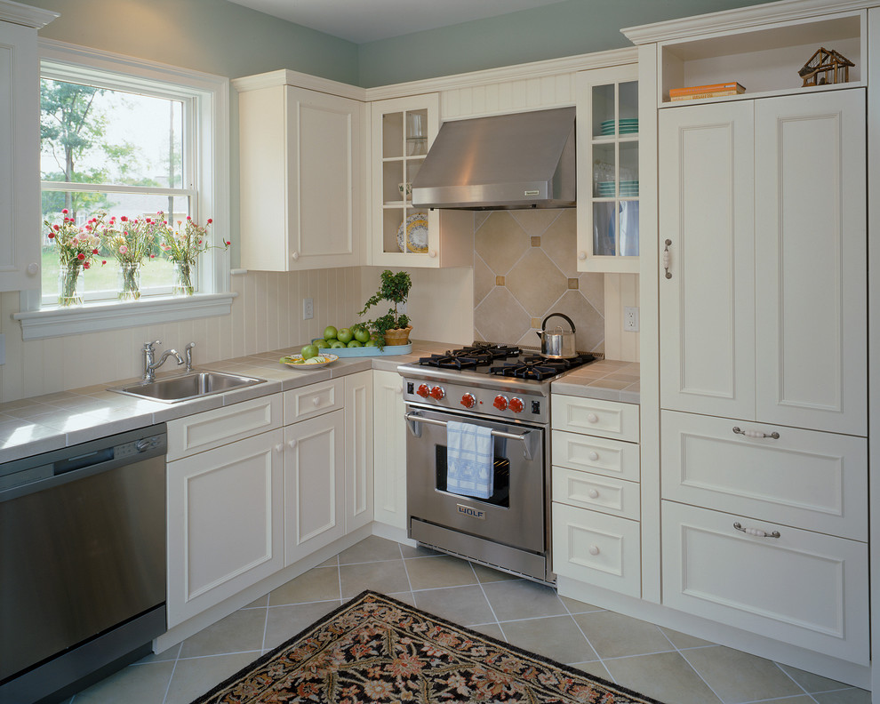 Inspiration for a traditional kitchen in New York with glass-front cabinets and stainless steel appliances.