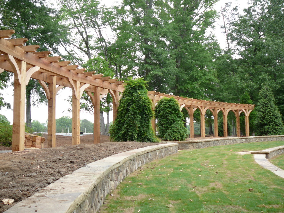 Mid-sized arts and crafts patio in Atlanta with natural stone pavers and a pergola.