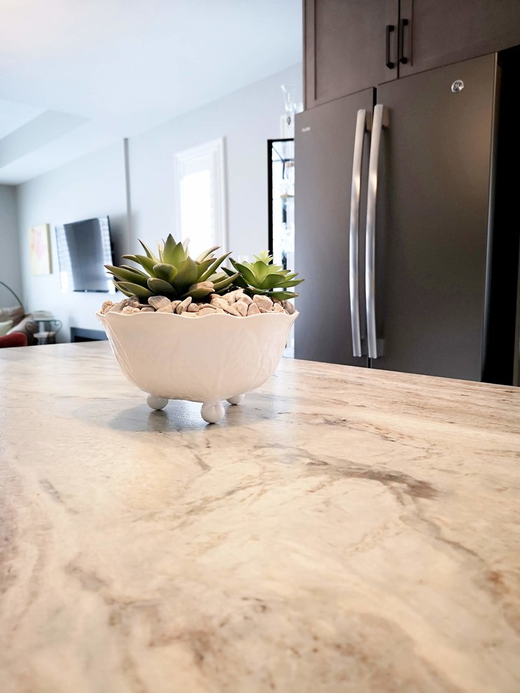 Open concept kitchen - mid-sized transitional l-shaped medium tone wood floor and brown floor open concept kitchen idea in Toronto with an undermount sink, shaker cabinets, light wood cabinets, granite countertops, white backsplash, porcelain backsplash, stainless steel appliances, an island and beige countertops