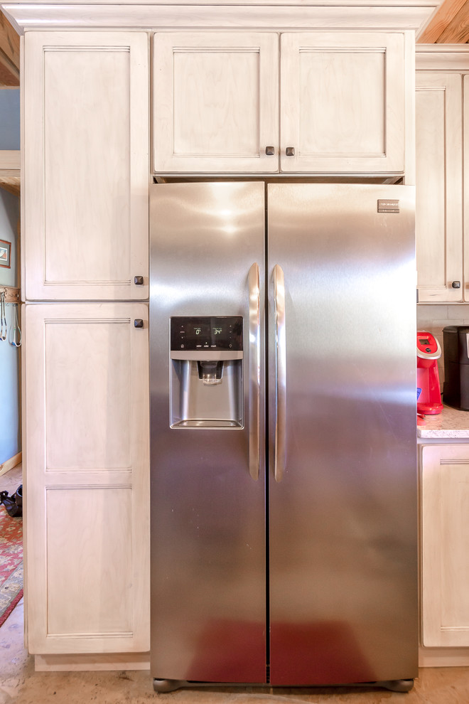 Mid-sized mountain style l-shaped beige floor enclosed kitchen photo in Denver with a farmhouse sink, medium tone wood cabinets, granite countertops, white backsplash, stainless steel appliances, an island and gray countertops